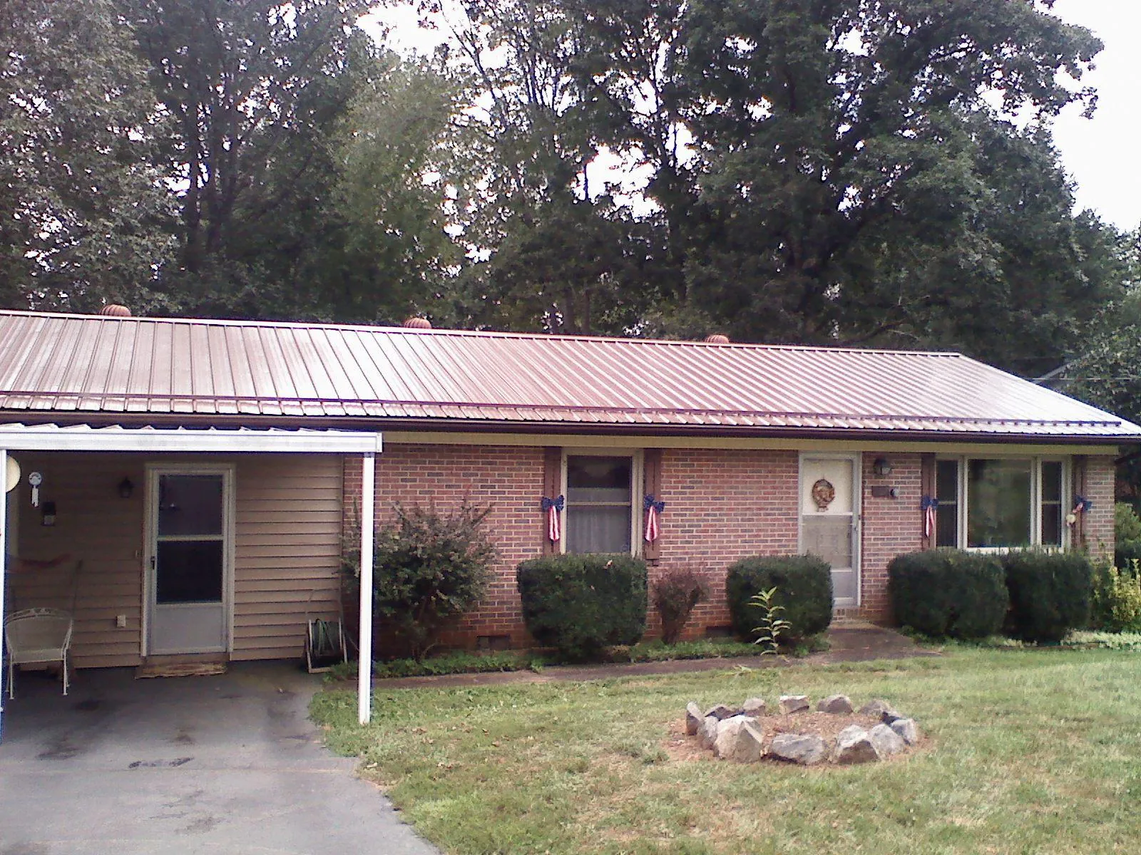 Bronze metal roof and carport on a brick ranch home — Roof Repair work by our crew in Tremont